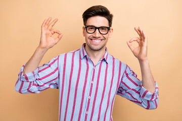 Portrait of young businessman showing double okay sign gesturing his good feedback to your job...