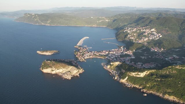 City view in the Amasra mountains. The drone is slowly approaching the beautiful landscape. Aerial view of houses and deep blue sea. Amasra, Turkey.