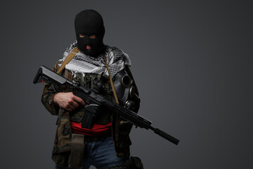 A Middle Eastern radical soldier dressed in a black balaclava and camouflaged field uniform, armed...