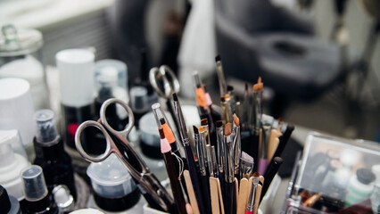 Cosmetics, brushes, pencils, scissors and other tools for the face. Makeup, skin care concept. The cosmetologist's workspace. - obrazy, fototapety, plakaty