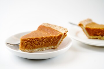 Sliced pumpkin pie isolated on white background, selective focus
