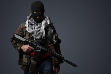 Portrait of a Middle Eastern radical soldier wearing a black balaclava and camouflaged field...