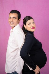 Happy pregnant Caucasian woman posing with her loving husband for a maternity shoot