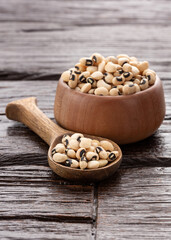 Raw black eye beans in the bowl and wooden spoon