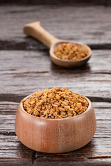 Fenugreek seeds in bowl and wooden spoon - healthy food