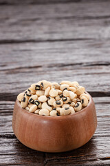 Raw black-eyed beans in the wooden bowl - Alubia carilla