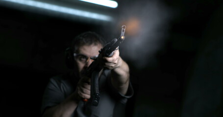 Man aiming and firing with weapon in super slow-motion 800 fps. Person holding an AK-47 Kalashnikov...