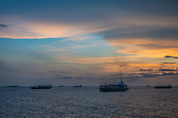Obraz premium Guatemala, Puerto Quetzal - July 20, 2023: Spectacular sunset above many waiting vessels anchored on Pacific ocean in front of harbor