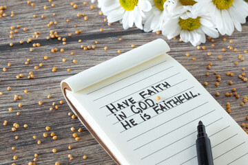 Have faith in God, He is Faithful. Inspiring Christian bible quote handwritten in notebook with...