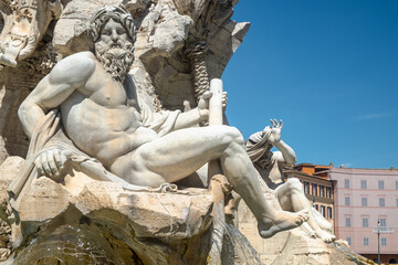 Fountain of the Four Rivers with the Ganges sculpture against a blue sky, Piazza Navona, Rome, Italy