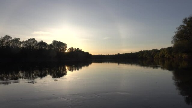 Unusual atmospheric phenomena. Very bright double halo (parhelic ring) over river at moment of evening sunset, windless spring day. Average flow of Don River. Mock sun with reflection in water