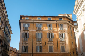 The orange facade of Palazzo Testa Piccolomini in the Trevi district of Rome, Italy