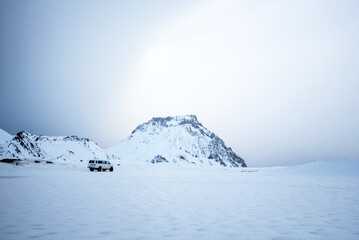Eco / adventure tour van with large tires for the snow on a icy glacial landscape in Iceland on an...
