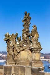 Obraz premium Baroque Statue on the Charles Bridge in the sunny snowy Day, Prague, Czech republic