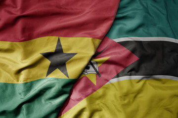 big waving national colorful flag of ghana and national flag of mozambique .