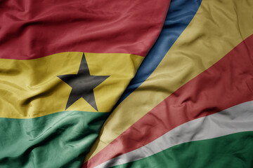 Fototapeta premium big waving national colorful flag of ghana and national flag of seychelles .