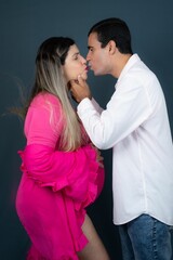 Happy pregnant couple embracing and sharing a romantic kiss