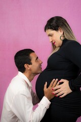 the husband tenderly resting his chin on the pregnant woman stomach