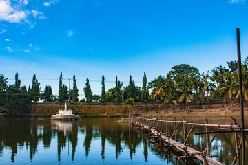 Obraz premium Picturesque small wooden bridge with palm trees in the background