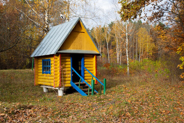 Wooden gazebo for a picnic in the woods on a fall day. A place for rest in the park.