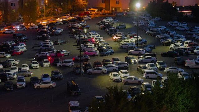 Timelapse: fast moving cars are leaving the parking lot of the exhibition center in the evening in Istanbul, Turkey - light trails. Transportation, rush hour, long exposure and time lapse concept