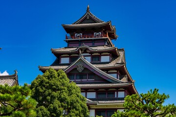 Traditional Chinese pagoda against a bright blue sky with white fluffy clouds in the background