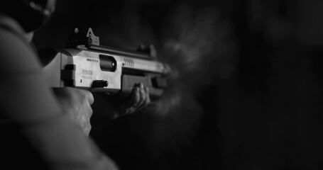 Monochrome shot of person firing a powerful shotgun and reloading shell bullet in black and white - obrazy, fototapety, plakaty