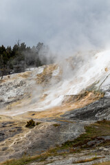 Mammoth hot springs in Yellowstone national park, image shows the steaming cliff coated in sulphur 