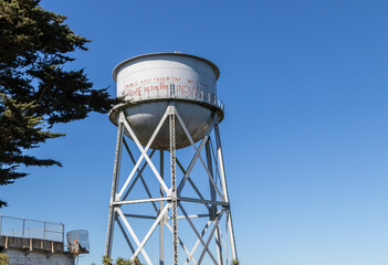 Alcatraz water tower, Image shows a close up of the disused water tower with the graffiti from Indian movement, with clear skies, October 2023