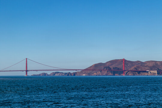 Golden gate bridge from across the bay, Image shows a beautiful blue calm pacific ocean, clear skies and the golden gate bridge in the San Francisco bay, October 2023