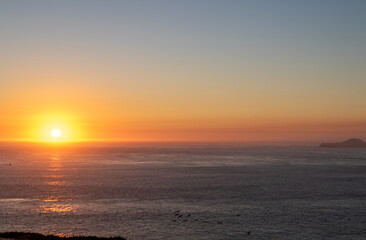 sunset over the pacific ocean, image shows the final moments of the sun setting over the san fancisco bay, california lighting up the sea and sky with various colours, taken october 2023