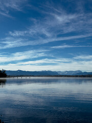 Blick über einen See in Bayern auf die Berge