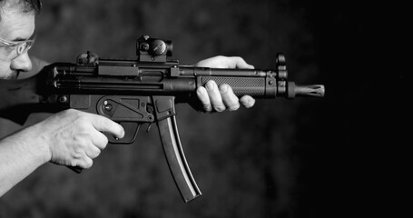 Side View of Person Aiming and Firing HK SP5K, High-Speed German Assault Rifle Shooting, in monochromatic black and white