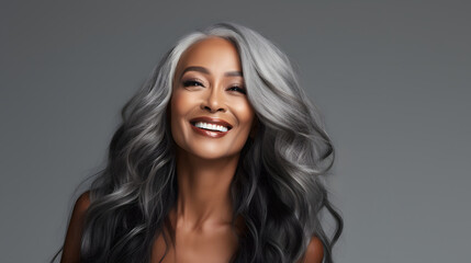 Beautiful black woman with smooth healthy face skin. Gorgeous aging mature woman with long gray hair and happy smiling. Beauty and cosmetics skincare advertising concept