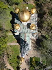 Aerial view of a Russian church with golden globes in Shipka village, surrounded by lush green trees