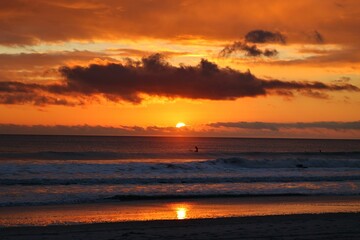 Obraz premium Surfer on the waves during sunrise at Jax Pier in Jacksonville, FL