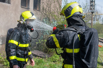 Funny moment where one firefighter washes another with a stream of water from a hose