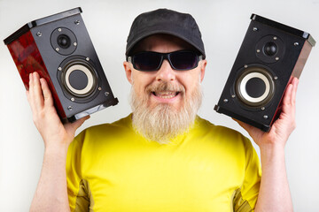 audio speakers in the hands of a bearded man. sound and modern media technologies