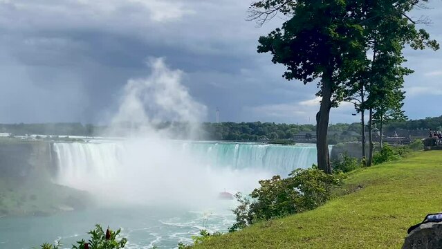 Looking at Horseshoe falls of Niagara Falls with the maid of the mist tour boat covered ib the mist of the falls.