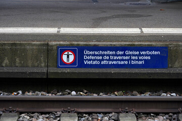Banner with a pictogram saying it is forbidden to cross the tracks at the railway station in...