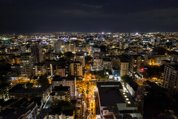 Fototapeta na wymiar Beautiful aerial Night view of the illuminated city of Santo Domingo - Dominican Republic with is Parks, buildings, suburbs ,turquoise Caribbean ocean, parks and malecon