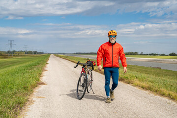 athletic senior cyclist with a gravel touring bike on a levee trail along Chain of Rocks Canal near Granite City in Illinois