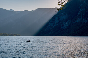 Sunset over the mountain lake Bohinj with boat