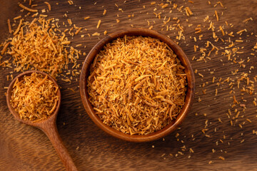 Grated coconut on wooden background.