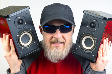 audio speakers in the hands of a bearded man. sound and modern media technologies