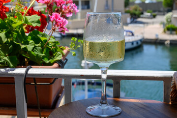 Glass of cold white wine in yacht harbour of Port Grimaud, summer vacation on French Riviera in Provence, France
