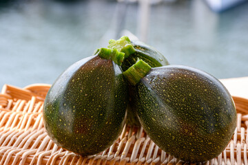 Round green courgette or zucchini, on wicked plate, close up, healthy food