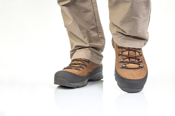 Trekking boots for hiking on the legs of a tourist on a white background. Equipment for travel and hiking