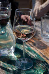 Drinking pinot grigio dry cold wine, served outdoor in beach cafe in North Holland, North sea sandy beach, the Netherlands