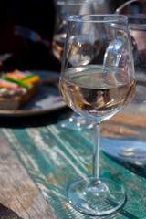 Drinking pinot grigio dry cold wine, served outdoor in beach cafe in North Holland, North sea sandy beach, the Netherlands